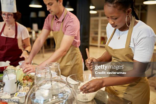 chef instruisant les étudiants pendant les cours de cuisine - cours de cuisine photos et images de collection