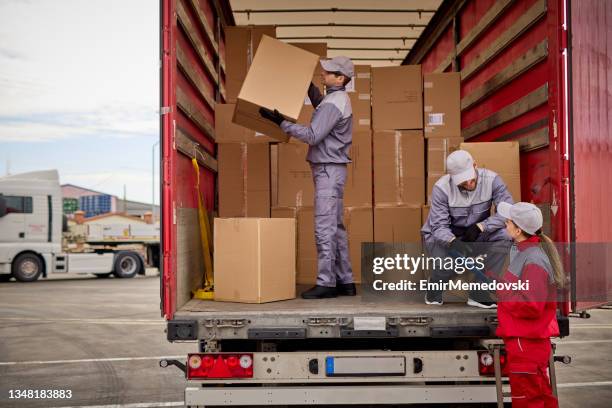 woman receiving delivery, signing a clipboard - pick-up imagens e fotografias de stock