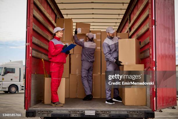 woman receiving delivery, signing a clipboard - cargo container truck stock pictures, royalty-free photos & images