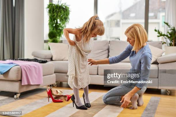 little girl in mothers dress and high heels at home - child high heels stock pictures, royalty-free photos & images