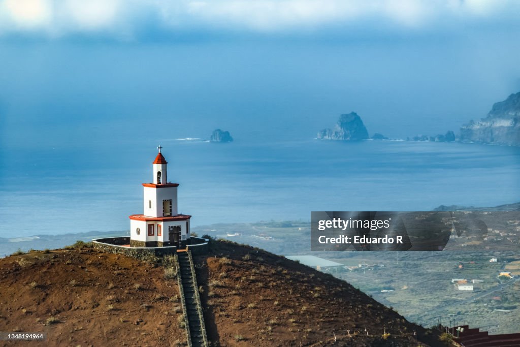 Bell tower on a mountain with the sea in the background