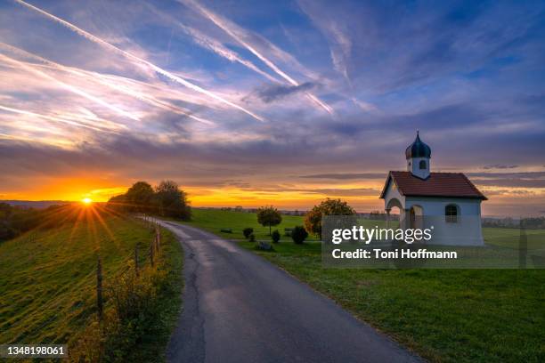 lonely road at a small bavarian chapel due sunset - ammersee stockfoto's en -beelden