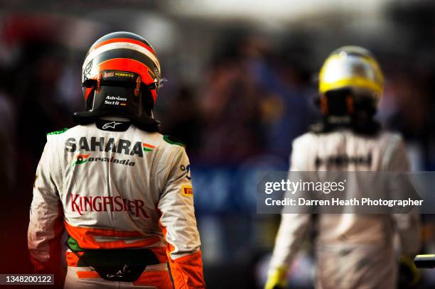 German Force India Formula One team racing driver Adrian Sutil wearing his fire proof protection suit racing driver overalls and a crash helmet...