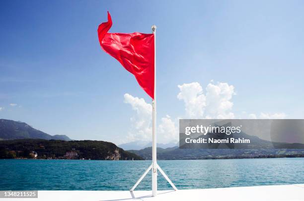 red pennant flag on a boat in lake annecy, france - red triangle flag photos et images de collection