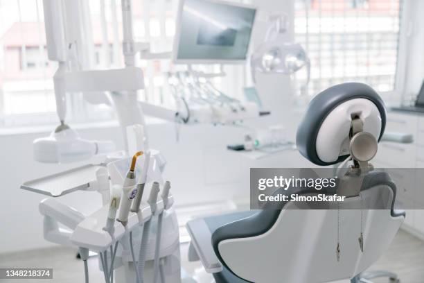 moderne zahnbohrer und leerer stuhl in der zahnarztpraxis - zahnarztstuhl stock-fotos und bilder