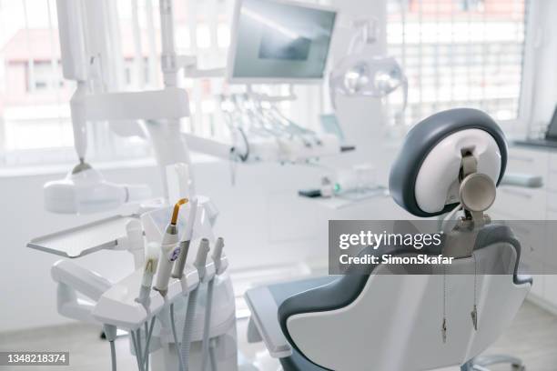 trapani dentali moderni e sedia vuota nello studio del dentista - ambulatorio dentistico foto e immagini stock