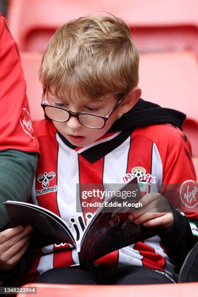 Young Southampton fan reads the matchday programme prior to kick off in the Premier League match between Southampton and Burnley at St Mary's Stadium...