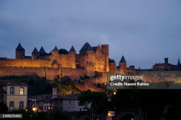 fortified medieval city of carcassonne illuminated at dusk, occitanie, france - carcassonne stock pictures, royalty-free photos & images