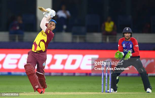 Shimron Hetmyer of West Indies plays a shot as Jos Buttler of England looks on during the ICC Men's T20 World Cup match between England and Windies...