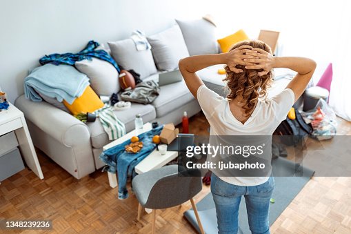 Dona de casa moderna em dia ensolarado olhando para o quarto sujo. Dona de casa moderna em dia ensolarado olhando para o quarto sujo.