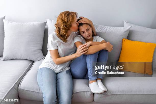 caring mother calming and hugging upset little daughter - depression sadness stock pictures, royalty-free photos & images