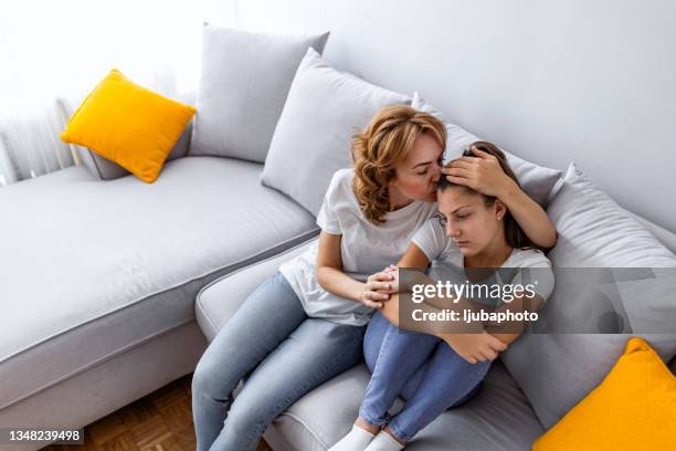 upset carrying 40 years old mature mother cuddling daughter. - 12 13 years old girls stock pictures, royalty-free photos & images
