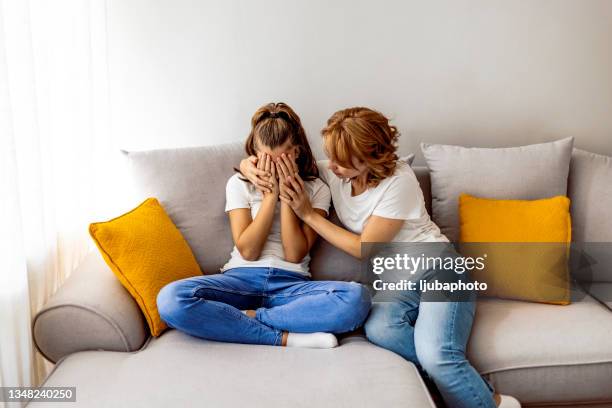 affectionate mature mommy supporting stressed teen daughter - tienerzwangerschap stockfoto's en -beelden