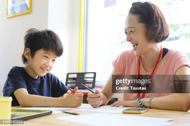 a teacher and a child are drawing. - special education stock pictures, royalty-free photos & images
