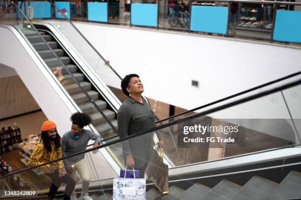 les gens sur l’escalator au centre commercial - escalator photos et images de collection