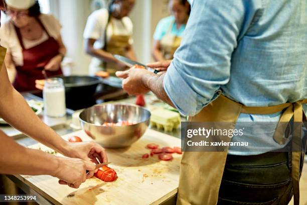 businesspeople participating in team cooking class - aula de culinária imagens e fotografias de stock