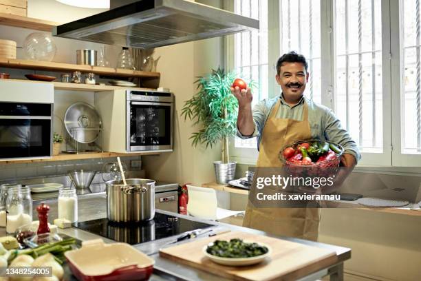 portrait of student holding vegetables in cooking classroom - collegebasket stock pictures, royalty-free photos & images