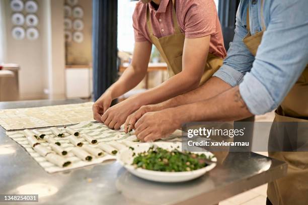 adult male students participating in team cooking event - cannelloni stock pictures, royalty-free photos & images