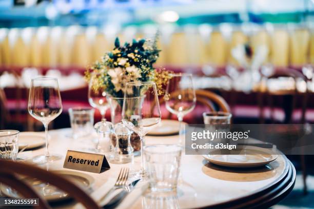 reserved sign on a decorated dining table with dinner place settings and centrepiece - hacer una reserva fotografías e imágenes de stock