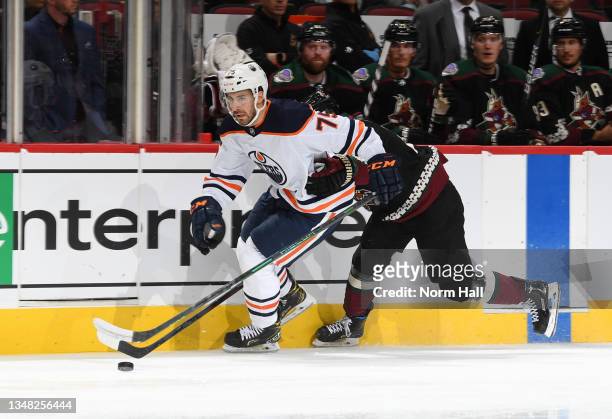 Evan Bouchard of the Edmonton Oilers skates with the puck against the Arizona Coyotes at Gila River Arena on October 21, 2021 in Glendale, Arizona.