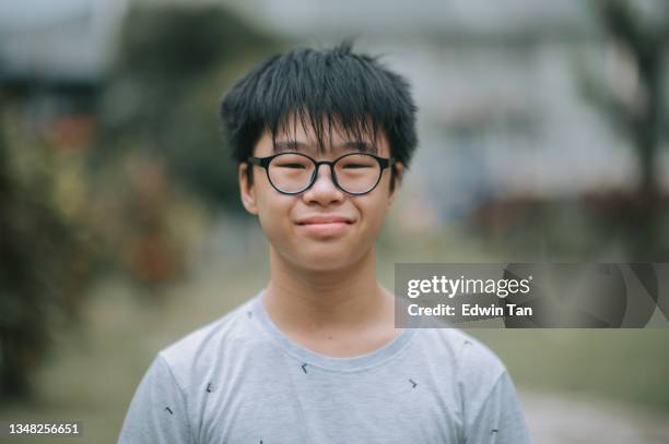 asian chinese teenage boy with eyeglasses looking at camera smiling at backyard of house outdoor - 12 year old cute boys stock pictures, royalty-free photos & images