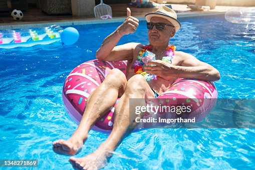 Senior man enjoying relaxing in swimming pool Senior man enjoying relaxing in swimming pool