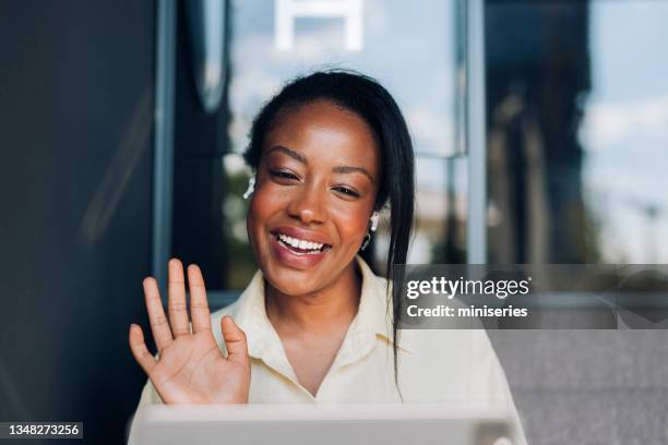 nahaufnahmefoto einer lächelnden geschäftsfrau, die bei einem videoanruf in einem café spricht - modern business people close up stock-fotos und bilder