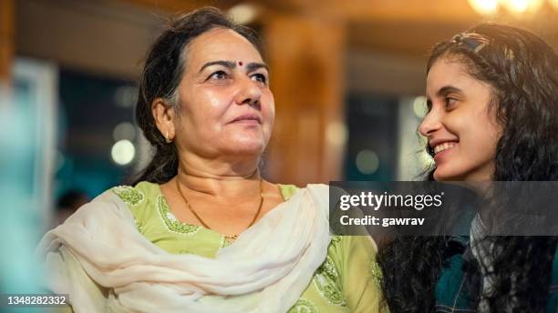 the senior woman and her daughter sit together in a restaurant. - south asia stock pictures, royalty-free photos & images