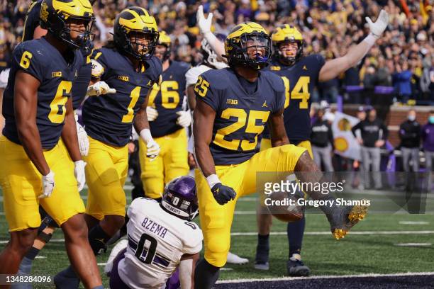 Hassan Haskins of the Michigan Wolverines celebrates a second half touchdown with teammates while playing the Northwestern Wildcats at Michigan...
