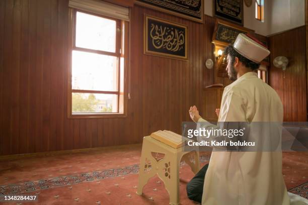 imam recites the quran and prays in the mosque. - imam stock pictures, royalty-free photos & images