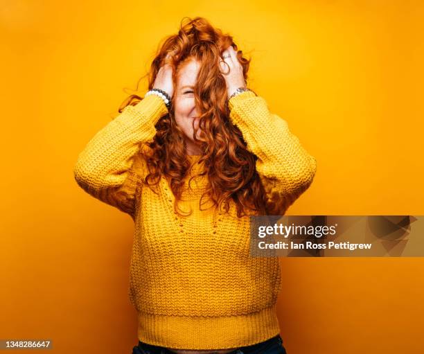 young woman, hands in hair - gelber hintergrund stock-fotos und bilder