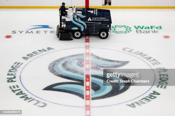 Ice resurfacing machines clear the ice over the logo after the Seattle Kraken's morning skate before the inaugural home opener against the Vancouver...