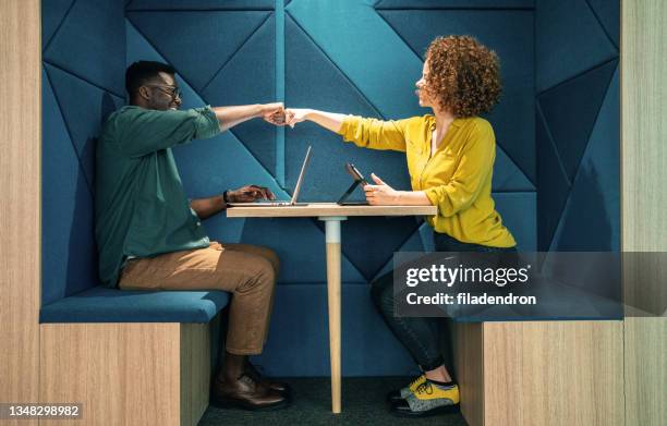 fist bump at modern office - greeting stock pictures, royalty-free photos & images