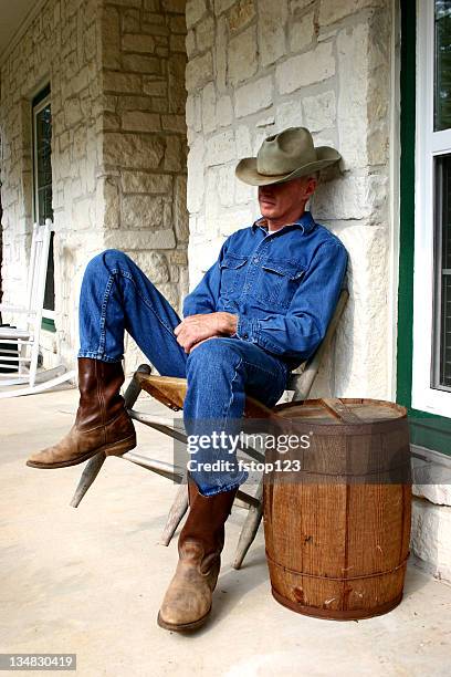 cowboy dozing in old chair on porch nail keg table - cowboy sleeping stock pictures, royalty-free photos & images