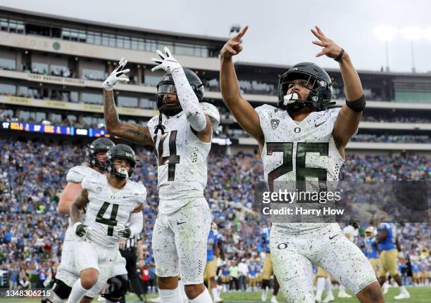 Travis Dye of the Oregon Ducks celebrates his touchdown with Kris Hutson and Mycah Pittman, to take a 27-17 lead over the UCLA Bruins, during the...