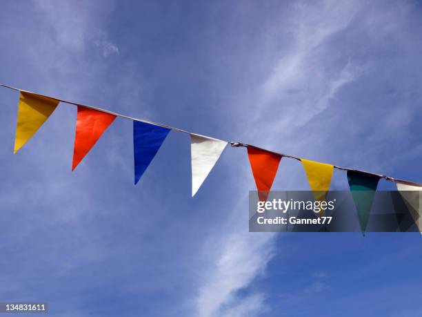 row of coloured flags against the sky - triangular flag stock pictures, royalty-free photos & images