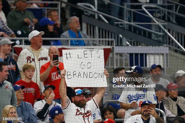 Fan holds a sign during the second inning of Game Six of the National League Championship Series between the Atlanta Braves and the Los Angeles...