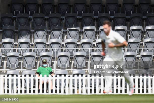 Fan wearing a face mask looks on as Doug Bracewell of the Central Stags runs in to bowl during the Plunket Shield match between Canterbury and...