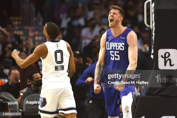 Isaiah Hartenstein of the Los Angeles Clippers reacts after a dunk as De'Anthony Melton of the Memphis Grizzlies looks on during the first half of a...