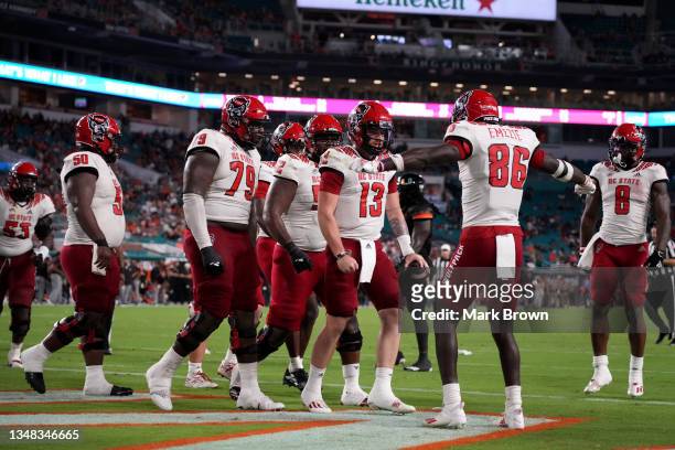 Devin Leary of the North Carolina State Wolfpack celebrates with teammates after running for a touchdown against the Miami Hurricanes during the...