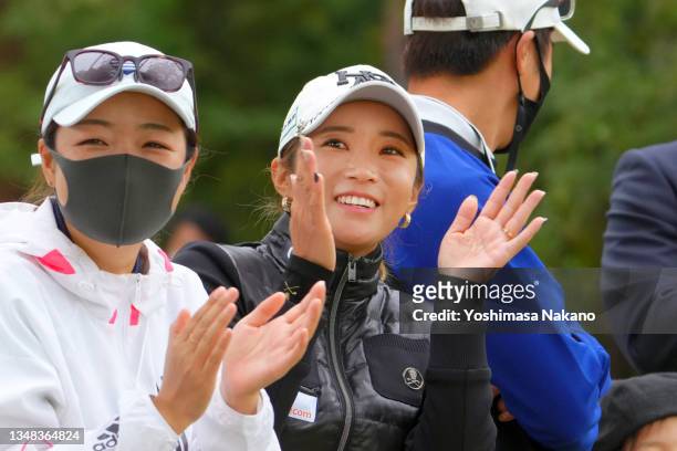 Bo-mee Lee of South Korea claps her hands as her friend and fellow golfer Ha-neul Kim playing on the final hole of her career on the 18th hole during...