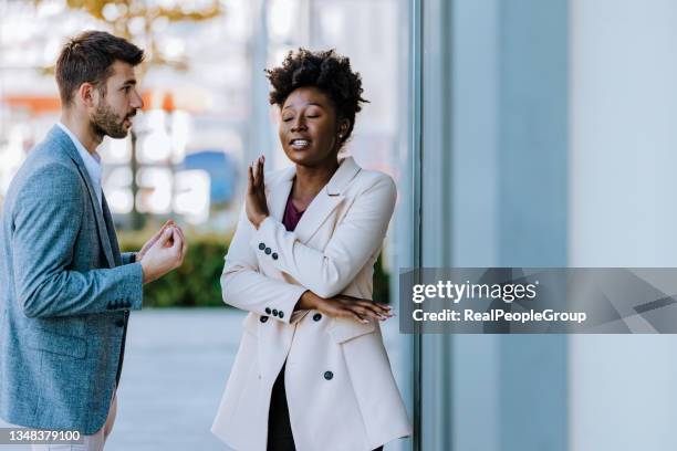 young mixed-race couple arguing in the city street - assertiviteit stockfoto's en -beelden