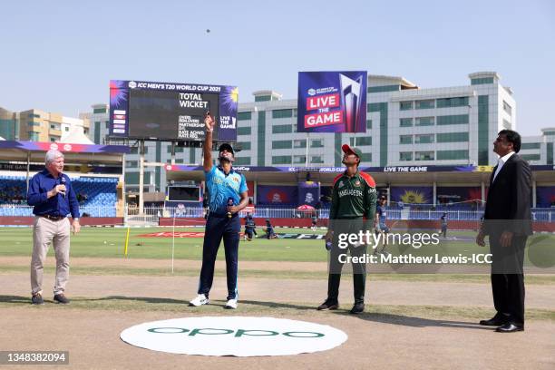 Dasun Shanaka of Sri Lanka flips the coin as Mahmudullah of Bangladesh looks on ahead of the ICC Men's T20 World Cup match between Sri Lanka and...