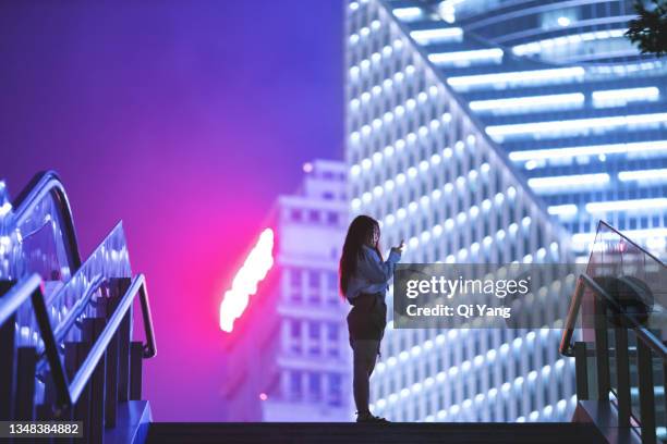 young businesswoman standing against contemporary financial skyscrapers in the downtown financial district - project greenlight stock pictures, royalty-free photos & images