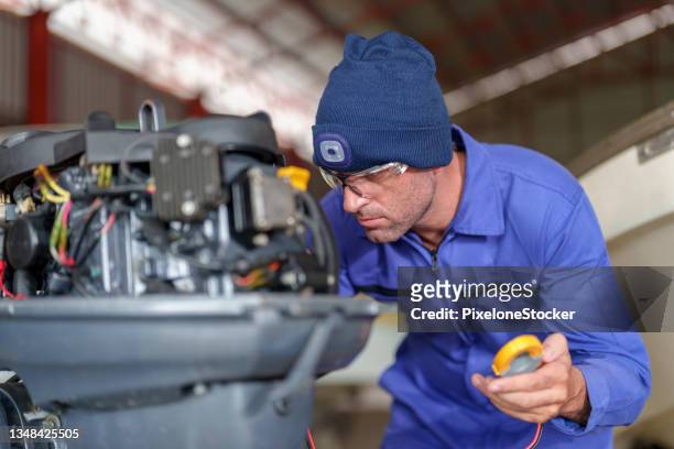 mechanic repairing the outboard engine in the workshop. - motor vessels stock pictures, royalty-free photos & images
