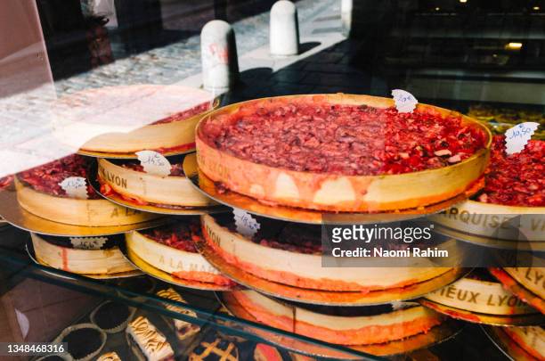 pink praline tarts stacked in a bakery window in lyon, france - 里昂 法國 個照片及圖片檔