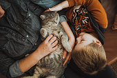 Mother and son playing with a cat at home