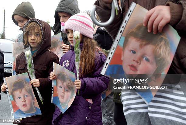 Little girls hold flowers and portraits of three-year-old child Bastien during a white walk on his memory, on December 4 in Germigny-l'Eveque, 40 km...