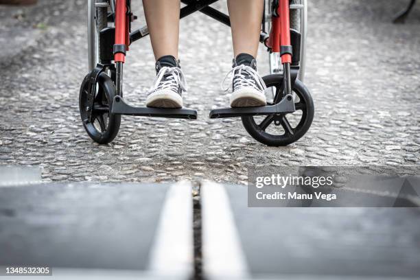 low angle of an image of a person's feet prepared to board a wheelchair ramp - disabled access fotografías e imágenes de stock