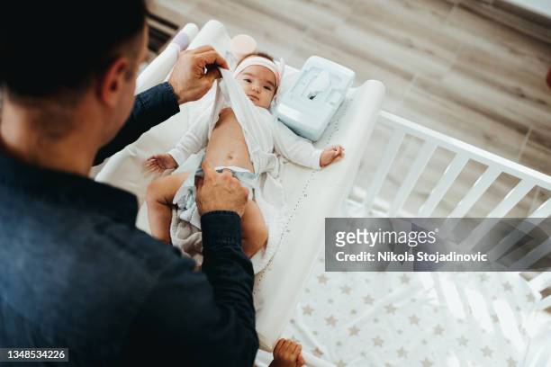 dad changes the baby's diaper - nappy change stockfoto's en -beelden